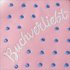 „Buchverliebt“ in weiß auf rosa Stoff mit blauen Punkten embroidered.