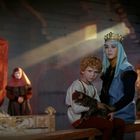 Keine sichtbaren Texte. Eine Frau mit Krone und ein Kind mit Katze vor einem luxuriösen, mittelalterlichen Innenraum.