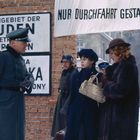 "WOHNGENIET DER JUDEN Betreten verboten" und "NUR DURCHFAHRT GESTATTET". Zwei Frauen mit Koffer und ein Soldat in Uniform.