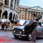 Texte: "LAURA ANTONELLI", "DAS NACKTE CELLO", "TELEFONI DI STATO". Ein Mann mit Cellokasten geht an einem Taxi vorbei. Pferdekutsche im Hintergrund.