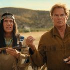 Zwei Männer stehen in einer wüstenartigen Landschaft, einer hält eine Friedenspfeife, der andere ein brennendes Streichholz.