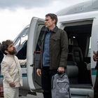 Eine Gruppe steht vor einem Hubschrauber. Eine Person hält eine Tasche mit "Bridge Data Network" darauf.