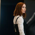 Keine Texte sichtbar. Eine Person mit rotem Haar im Profil, im Hintergrund unscharfe Schwarz-Weiß-Fotografie.