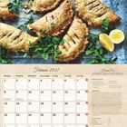 Februar 2027 Kalenderseite mit Rezept für vegane Hand Pies. Zeigt goldbraune Teigtaschen mit Sesam und Zitronen.