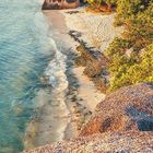 Kalenderseite für Februar, GEO-Logo. 

Strand mit klarem Wasser, großen Felsen und üppiger Vegetation bei Sonnenuntergang.