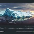 Der Monat "Januar". Ein großer Gletscher spiegelt sich im ruhigen, dunklen Wasser unter einem bewölkten Himmel.