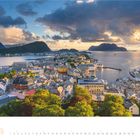 Mai 2027 Kalenderblatt, darunter Monatsübersicht. Hafenstadt mit bunten Dächern, umgeben von Wasser und Bergen bei Sonnenuntergang.