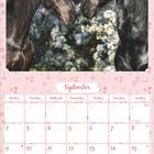 "September" in geschwungener Schrift; Kalender mit pinkem Blumenrahmen; zwei Pferde schauen sich an, Hintergrund: blühende Bäume.