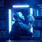 Text "CREATURE EATS". Eine Figur in Maske und kariertem Hemd steht vor Regalen voller Videokassetten, beleuchtet von blauem Licht.