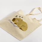 Auf einer Stofftasche schläft ein Capybara auf einem Buch, mit "Zzz" über ihm als Zeichen des Schlafens.