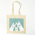 Beige Stofftasche mit Illustration von drei weißen, lächelnden Lamas vor einem blauen Hintergrund.