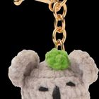 Text: "Kleiner Mutmacher", "Du bist toll!", "Pattloch".  
Plüsch-Koala-Anhänger mit grünem Hut und goldfarbenem Ring auf türkisfarbenem Hintergrund.