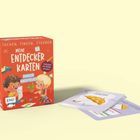 Auf der Box steht: "SUCHEN, FINDEN, STAUNEN. MEINE ENTDECKERKARTEN. INDOOR ABENTEUER. Suchspiel für Kinder ab 3 Jahren." 
Links eine rote Box, rechts Karten mit einem bunten Regenschirm.
