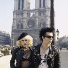 Zwei Personen in Punk-Outfits mit Lederjacken vor der Kathedrale Notre-Dame de Paris.