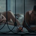 Keine sichtbaren Texte. Mann und Frau liegen nebeneinander im Bett, beide schauen nachdenklich.
