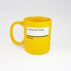 „Universal-Tasse“ und „Reclam“ auf gelbem Hintergrund einer Tasse mit Henkel.