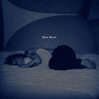 Text: "Blue Movie". Eine Person liegt seitlich auf einem Bett in blauem Licht, wirkt nachdenklich und entspannt.