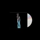 Kein Text vorhanden. Eine Person in fließendem Kleid hebt die Arme, daneben eine Disc mit Regenbogenreflexion.