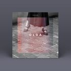 Das Cover zeigt die Texte "TOUCHING," "OLGA," "THE INVINCIBLE." Darauf ein rotes Quadrat und Gehweg aus Pflastersteinen. Rechts eine CD.