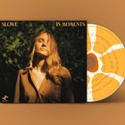 "Slowe" und "In Moments" in goldener Schrift. Eine Frau steht in der Natur, beleuchtet von warmem Sonnenlicht.