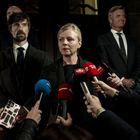 Mikrofone mit Logos: TV2, EXPRES. Frau in der Mitte, ernst, von Kameras und Reportern umgeben. Mehrere Männer im Hintergrund.