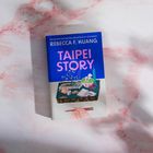 „Taipei Story“ von Rebecca F. Kuang. Ein Tisch mit asiatischem Essen und roten Essstäbchen auf einem marmorierten Hintergrund.