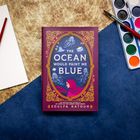 Ein Buch mit dem Titel "The Ocean Would Paint Me Blue" von Zoulfa Katouh. Rotes Design mit goldenen Verzierungen.