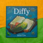 „Diffy“, „Caldecott Honoree“, Brian Lies. Illustration mit Fisch, offenem Buch, Dinosaurier, Gitarre und Pinsel auf blauem Grund.