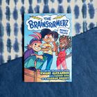 Ein Comic mit dem Titel "The Brainstormerz: Money Talks". Drei fröhliche Kinder in bunter Kleidung stehen zusammen.