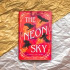 „THE NEON SKY“ von Alyssa Villaire, mit fliegenden Raben und Flammen auf rotem Hintergrund, verziert mit goldenen Mustern.