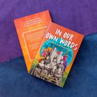 "IN OUR OWN WORDS: True Stories of Indian Boarding Schools" auf orangefarbenem Buchcover mit historischem Foto von Schülern.
