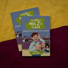 Zwei Buchcover mit der Aufschrift: "The Kids in Mrs. Z's Class - Sebastian Metzger Solves a Sticky Situation". Cartoon-Stil.