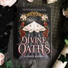 "Divine Oaths" von Elizabeth Agyemang. Illustration: eine Motte, Mond, Blumenornamente. Umgeben von Rosen und Blättern.