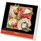 Text: "The Antipasto Plate (recipe follows). Friday, July 9, 2027."  
Ein Holzbrett mit Brot, Käse, Wurst und Oliven.