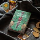Buch "Natalie Haynes - No Friend to This House" auf Stoff, umgeben von Tarotkarten und goldenen Plättchen.