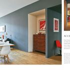 ACENTS OF ORANGE. Großer, heller Raum mit Esstisch, weißen Stühlen, Blumen, modernen Möbeln und orangefarbenen Akzenten.