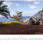 "Los Gigantes", "CASARES EDITION", darunter Kalenderdaten. Landschaft mit Palmen, Blumen, einem großen Felsen und Meerblick.