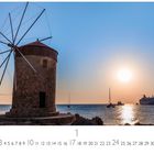 "Abendstimmung" und "CASARES EDITION". Ein Windmühlenbauwerk am Meer bei Sonnenuntergang, Boote und ruhiges Wasser.