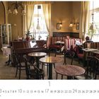 Café Zartel. Ein gemütliches Café mit klassischen Möbeln, einem Klavier und Gästen, die Zeitung lesen.