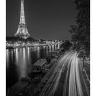 "An der Seine" steht unten links. Kalender mit Tagen, darunter beleuchteter Eiffelturm und Lichtspuren von Autos entlang des Flusses.
