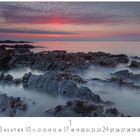 "Abendstimmung" steht unter einem Foto mit einem ruhigen Meer bei Sonnenuntergang und felsiger Küste.