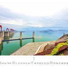 "Drei Schluchten Damm". Eine große Staumauer mit roten Strukturen, umgeben von Wasser und grüner Landschaft.