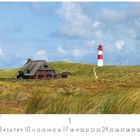 Reetdachhaus mit Leuchtturm, eingebettet in Dünenlandschaft unter blauem Himmel mit weißen Wolken.