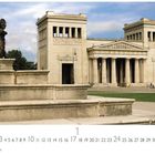 "Königsplatz" ist zu lesen. Ein klassisches Gebäude mit Säulen und eine Statue auf Steinstufen im Vordergrund.