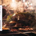 Text beschreibt Weihnachtsreiseziele und Kosten in verschiedenen Ländern. Rechts steht "DECEMBER" auf blauem Hintergrund. Im Hintergrund dampfende Speisen auf dem Grill.