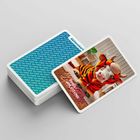 Spielkarte: Ein junges Rind in einem Tigerkostüm, mit dem Text "SPIELANLEITUNG" und "Aktion“. Stapel Karten im Hintergrund.