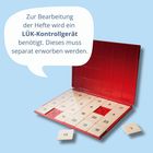 Text in Sprechblase: "Zur Bearbeitung der Hefte wird ein LÜK-Kontrollgerät benötigt. Dieses muss separat erworben werden." Darunter ein rotes Klappgerät mit durchnummerierten Plättchen.