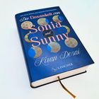 Buchtitel: "Die Einsamkeit von Sonia und Sunny" von Kiran Desai. Dunkelblaues Cover mit bunten Kreisen, Verlag S. Fischer.