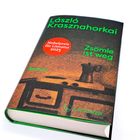 Text: "László Krasznahorkai, Nobelpreis für Literatur 2025, Zsömle ist weg, Roman." Buchcover in dunklen Tönen.