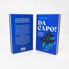 Zwei blaue Buchrücken, einer mit Text zu menschlichen Dramen in klassischer Musik, der andere mit Titel "DA CAPO!" und einem Klavier.